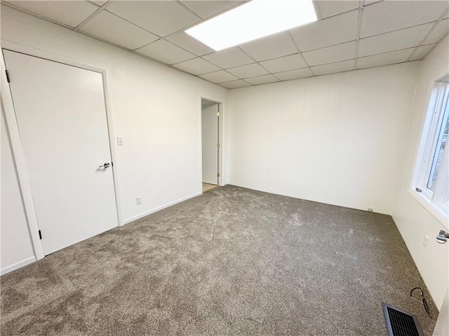 unfurnished room with carpet floors, a paneled ceiling, and visible vents