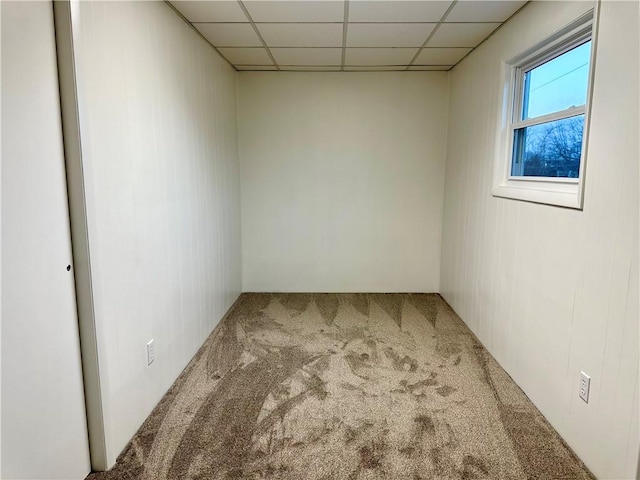 carpeted empty room featuring a drop ceiling