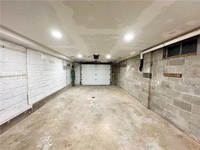 garage with concrete block wall and a garage door opener