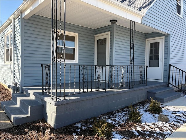 property entrance featuring a porch and roof with shingles