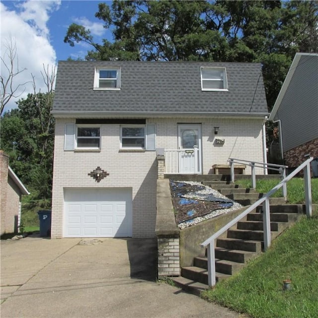 view of front of property featuring a garage, concrete driveway, stairway, and roof with shingles