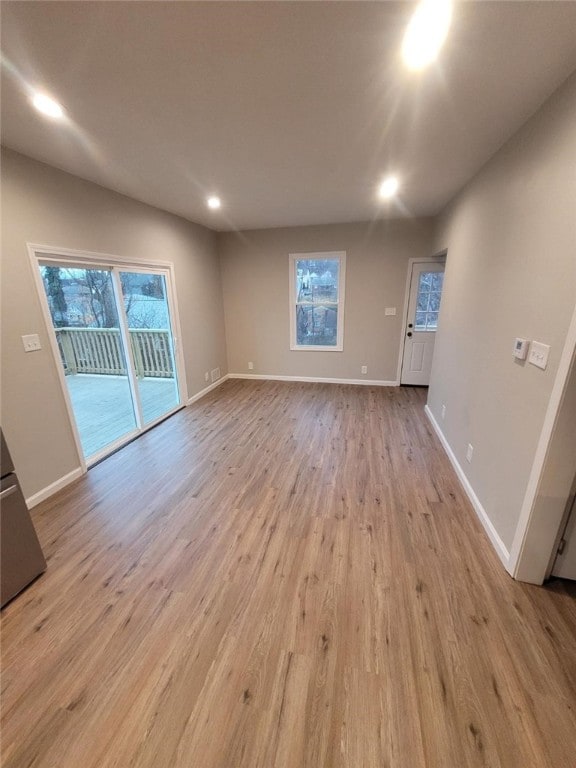 unfurnished living room with a healthy amount of sunlight, light wood-style flooring, and baseboards