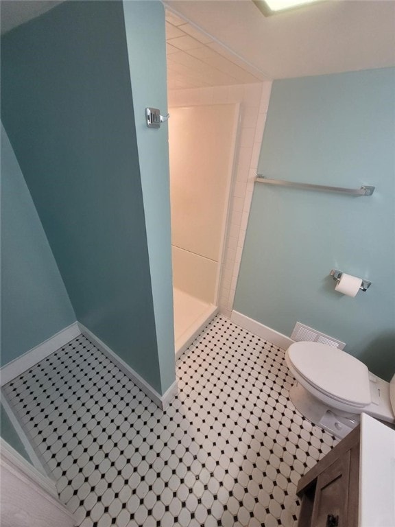 full bath with a stall shower, toilet, and baseboards