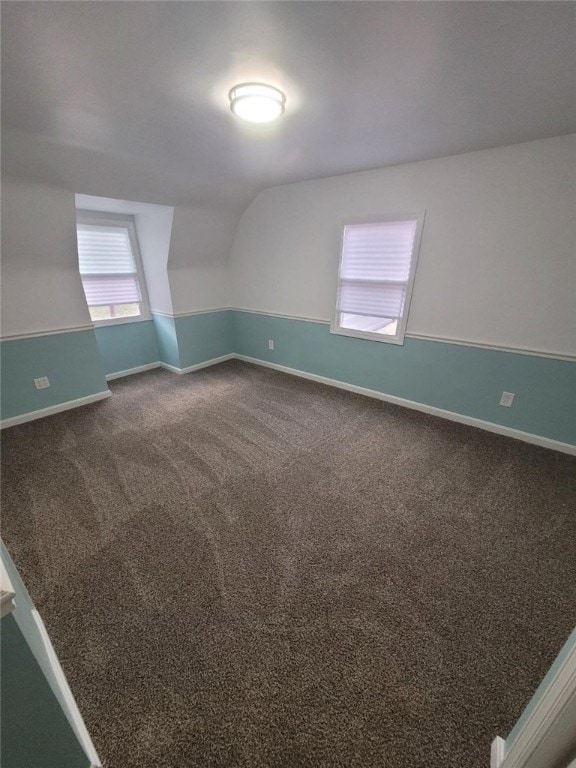 unfurnished room with lofted ceiling, carpet floors, and baseboards