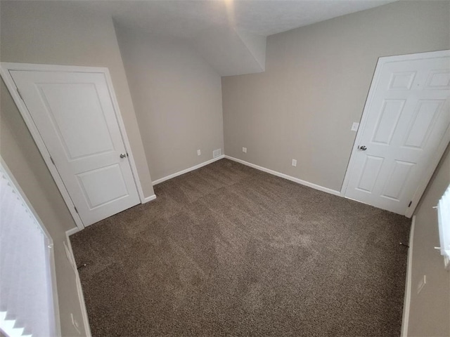 unfurnished bedroom with baseboards and dark carpet