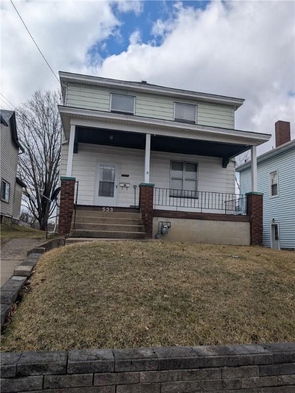 view of front of property featuring covered porch and a front lawn