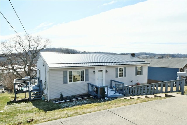 view of front of property featuring a front yard and metal roof