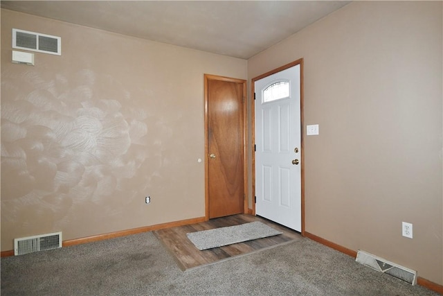 carpeted foyer with visible vents and baseboards