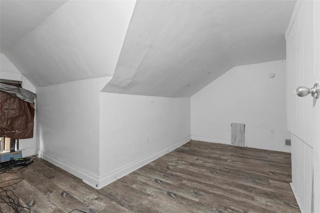 additional living space featuring lofted ceiling, baseboards, and wood finished floors