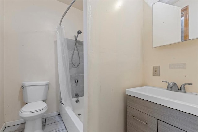 bathroom featuring shower / bath combo with shower curtain, vanity, toilet, and baseboards