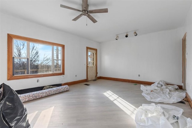 living area featuring rail lighting, visible vents, ceiling fan, wood finished floors, and baseboards