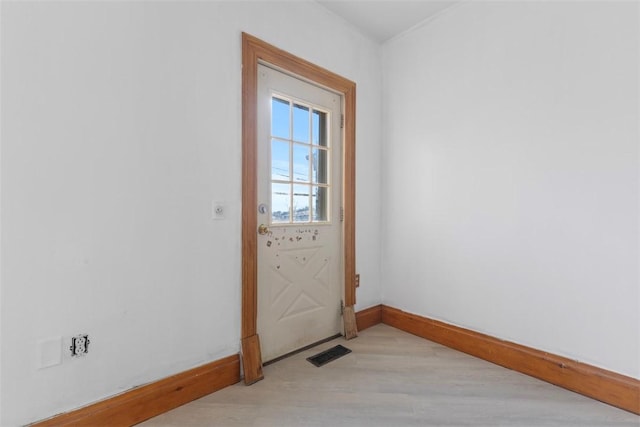 doorway to outside featuring light wood finished floors, visible vents, and baseboards