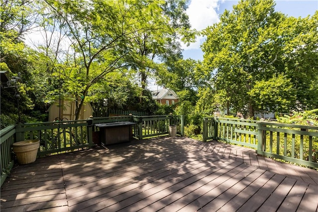 wooden deck with a storage shed and an outbuilding