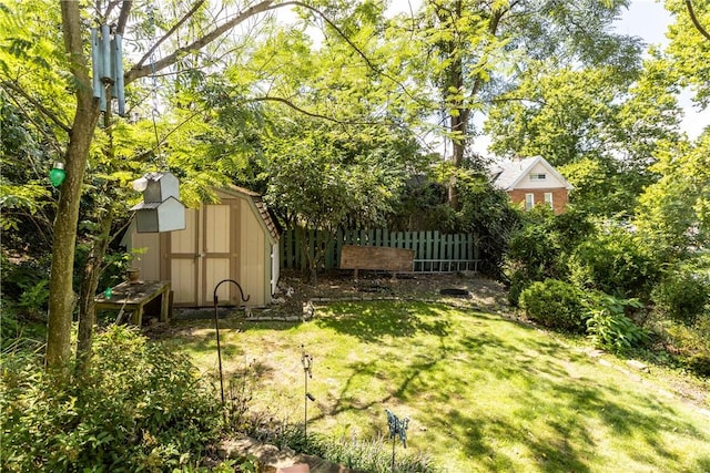 view of yard with an outbuilding, a shed, and fence