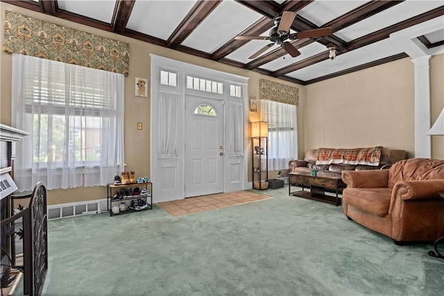 carpeted living area with coffered ceiling, a ceiling fan, ornamental molding, beamed ceiling, and ornate columns