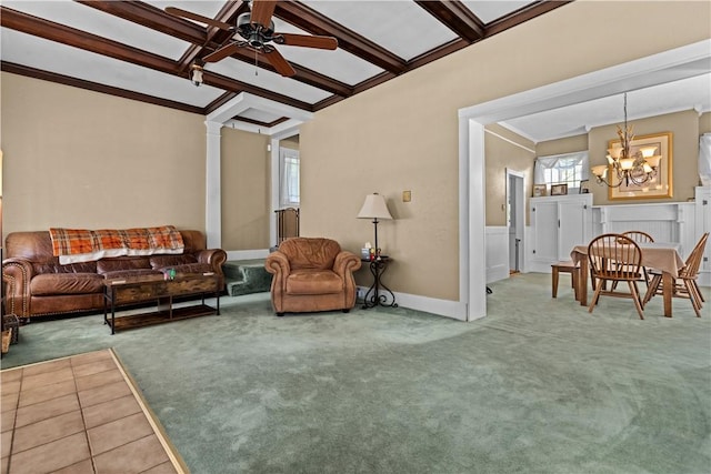 carpeted living room featuring decorative columns, ornamental molding, beam ceiling, and ceiling fan with notable chandelier