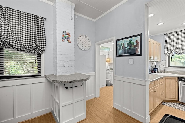 kitchen featuring ornamental molding, a sink, and light wood-style flooring