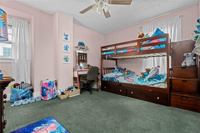 carpeted bedroom featuring ceiling fan and a textured ceiling