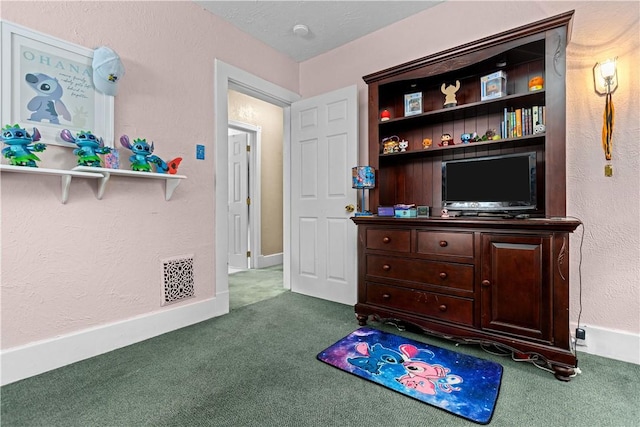 rec room featuring carpet flooring, a textured wall, visible vents, and baseboards