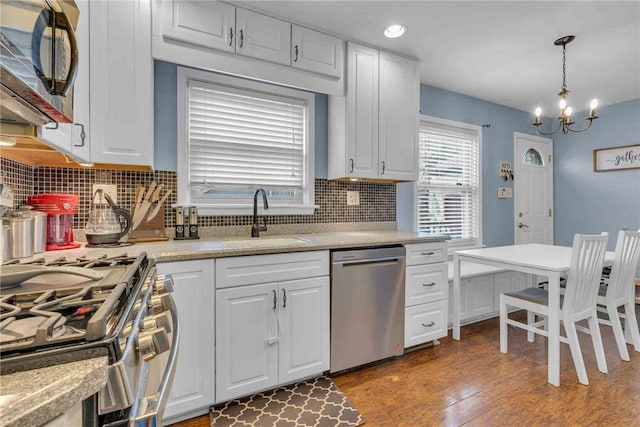 kitchen with appliances with stainless steel finishes, light countertops, white cabinetry, and a sink