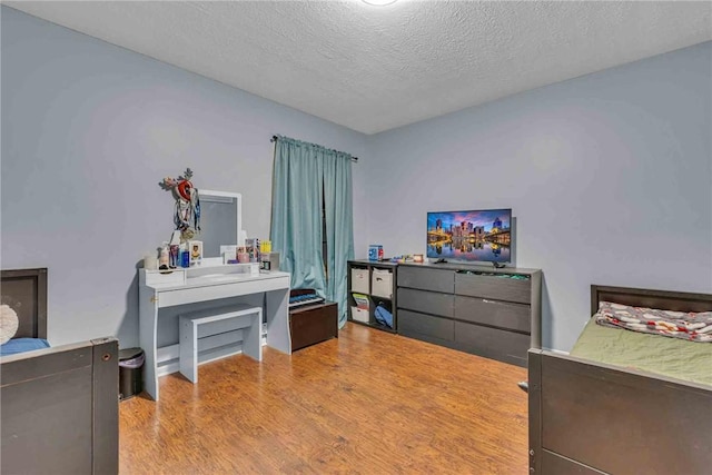 bedroom featuring a textured ceiling and wood finished floors