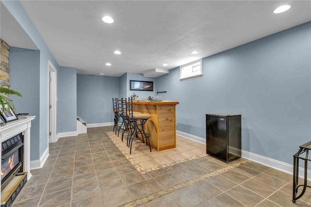 bar featuring baseboards, a dry bar, and recessed lighting