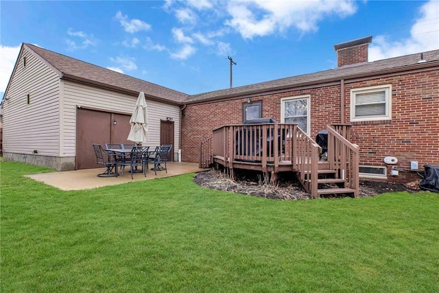 back of property featuring brick siding, a lawn, a chimney, and a patio