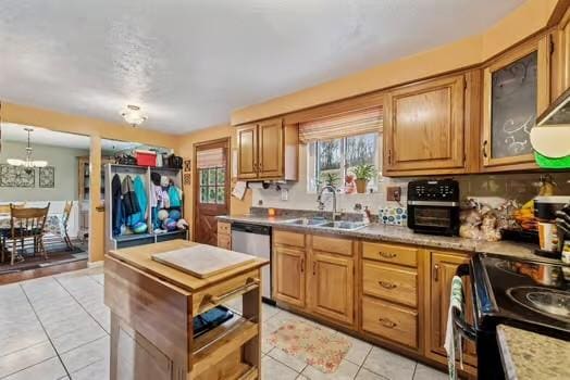 kitchen featuring brown cabinetry, a sink, black electric range, stainless steel dishwasher, and light tile patterned flooring