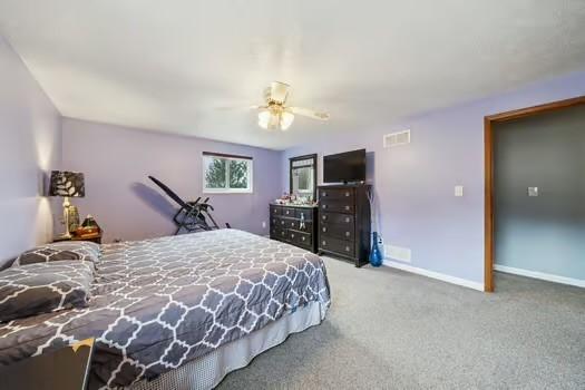 carpeted bedroom featuring baseboards and visible vents