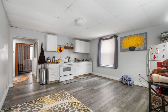 kitchen featuring white gas stove, dark wood-style flooring, and a drop ceiling