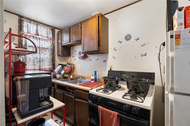 kitchen featuring white appliances, light countertops, and a sink