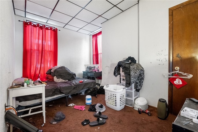 carpeted bedroom featuring a drop ceiling