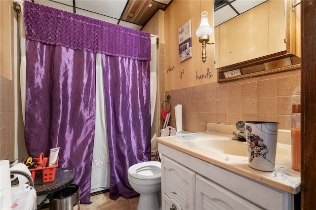 full bath featuring toilet, vanity, tile walls, wainscoting, and a shower with curtain