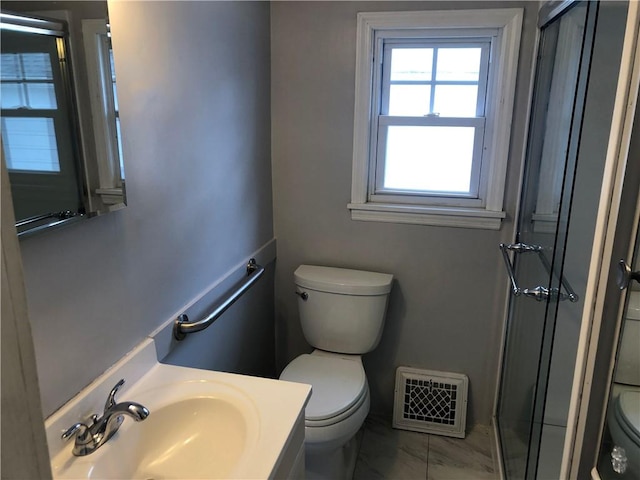 bathroom with visible vents, a shower with door, vanity, and toilet