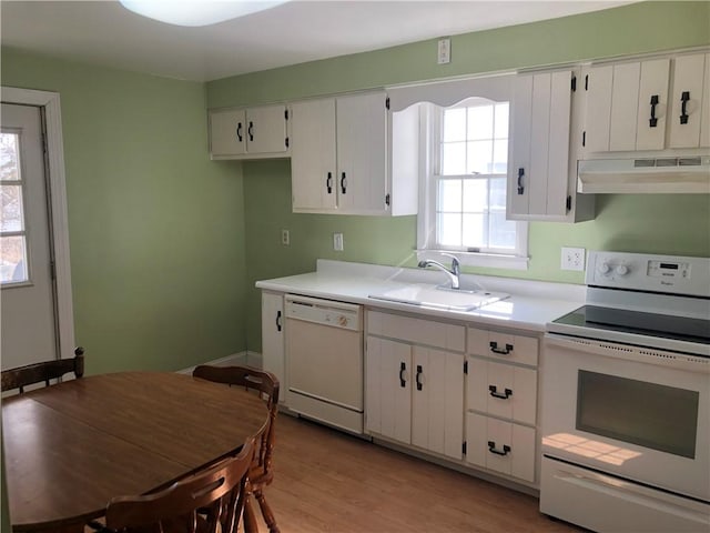 kitchen featuring under cabinet range hood, white appliances, a sink, white cabinets, and light countertops