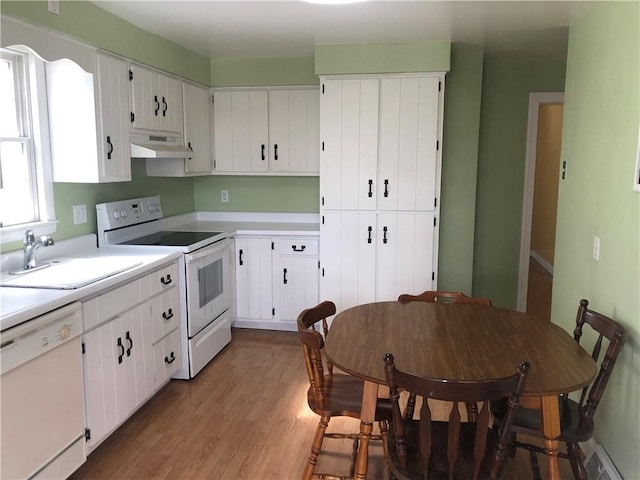 kitchen featuring light countertops, white appliances, a sink, and under cabinet range hood