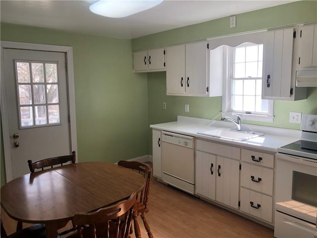 kitchen featuring light countertops, white appliances, a sink, and white cabinetry