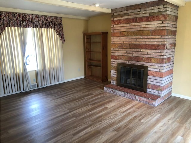 unfurnished living room with a stone fireplace, wood finished floors, visible vents, and baseboards