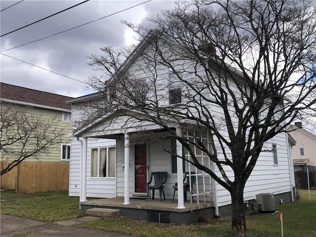 view of front of home with central AC unit, fence, and a porch