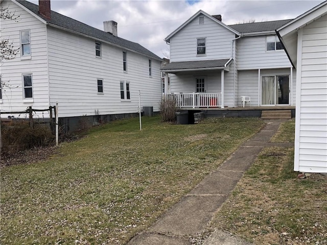 back of house with a porch and a lawn