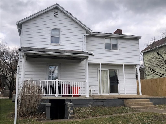 rear view of house with a porch and a chimney