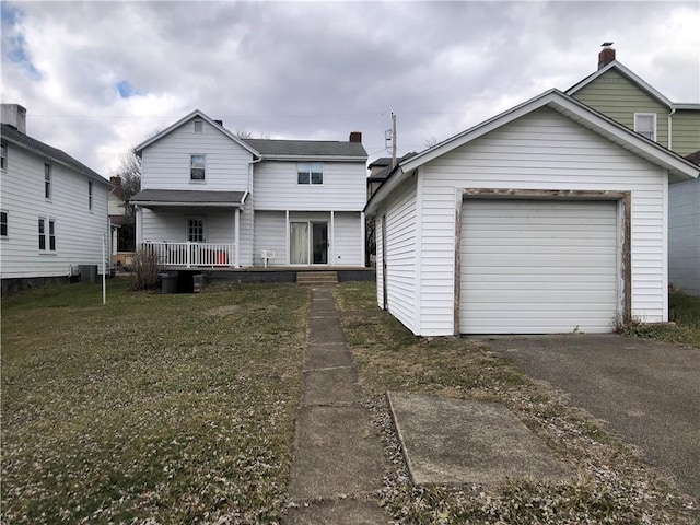 traditional-style home featuring a garage, a front lawn, aphalt driveway, and central AC