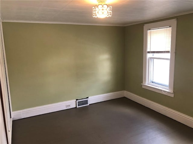 unfurnished room featuring visible vents, baseboards, dark wood finished floors, and crown molding