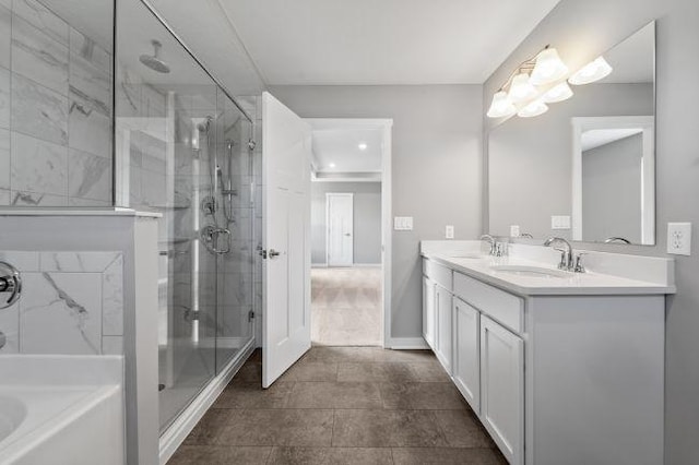 bathroom with double vanity, a shower stall, a sink, and a bath