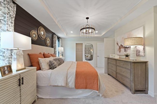 bedroom with light carpet, a raised ceiling, and an inviting chandelier