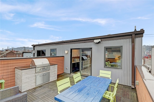 wooden deck featuring grilling area, exterior kitchen, and outdoor dining space