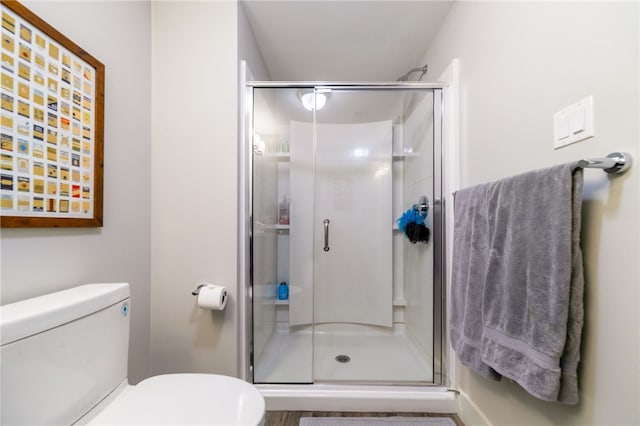 bathroom featuring a stall shower and toilet