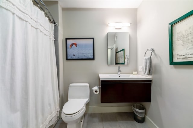 bathroom with curtained shower, toilet, vanity, baseboards, and tile patterned floors