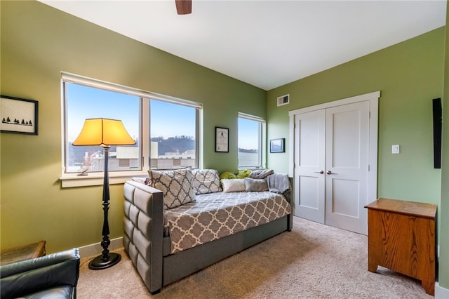 bedroom featuring a ceiling fan, a closet, visible vents, and carpet flooring