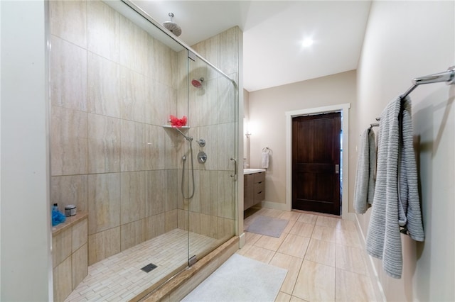 bathroom with baseboards, a shower stall, vanity, and tile patterned floors